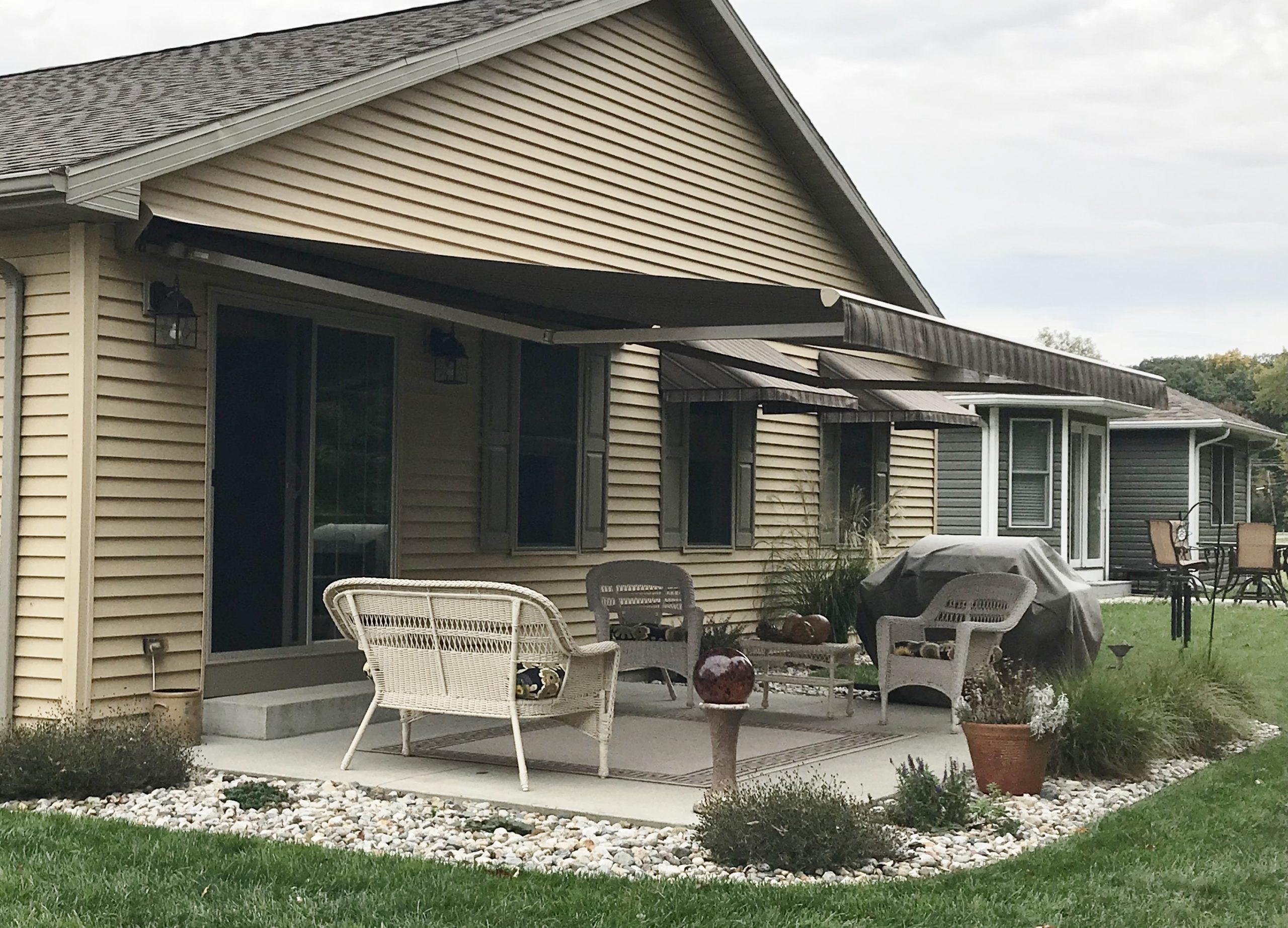 Retractable awning shading a Kansas City patio with a Sentry solar screen on the open edge